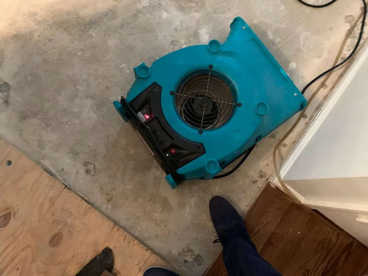 Air mover drying subfloor during Commercial Water Damage Restoration in Wheeling